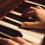 Mani che suonano su pianoforte
