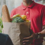 Mani che porgono un pacco di alimenti